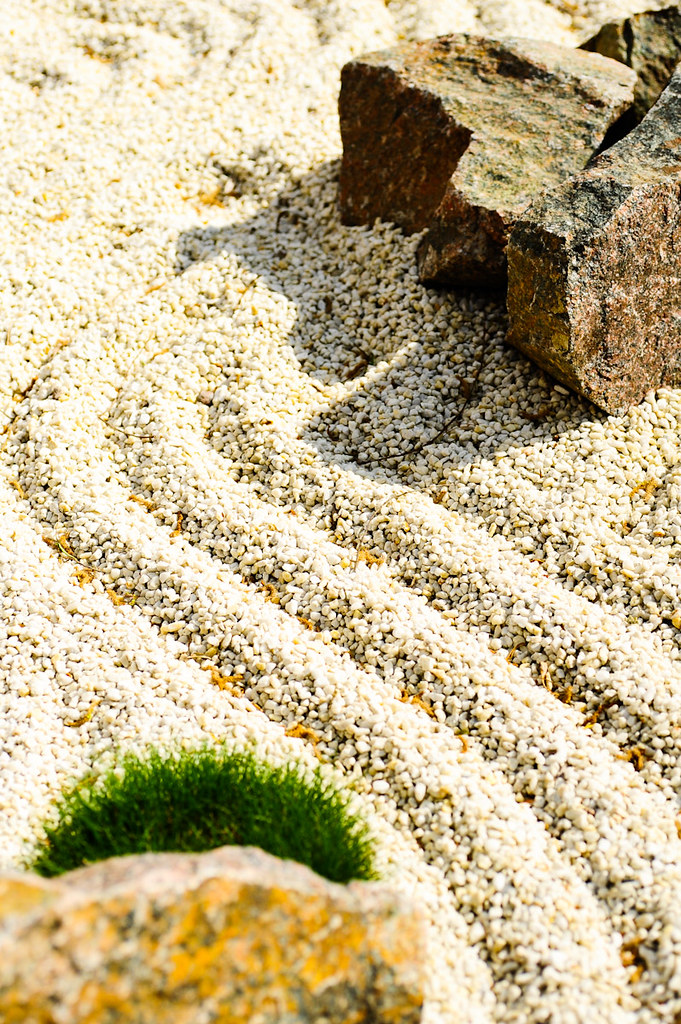 Zen-Garten mit geharktem Kies, Steinen und Moos